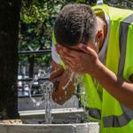 Lavoratore trova refrigerio presso una fontana, dove si bagna il viso