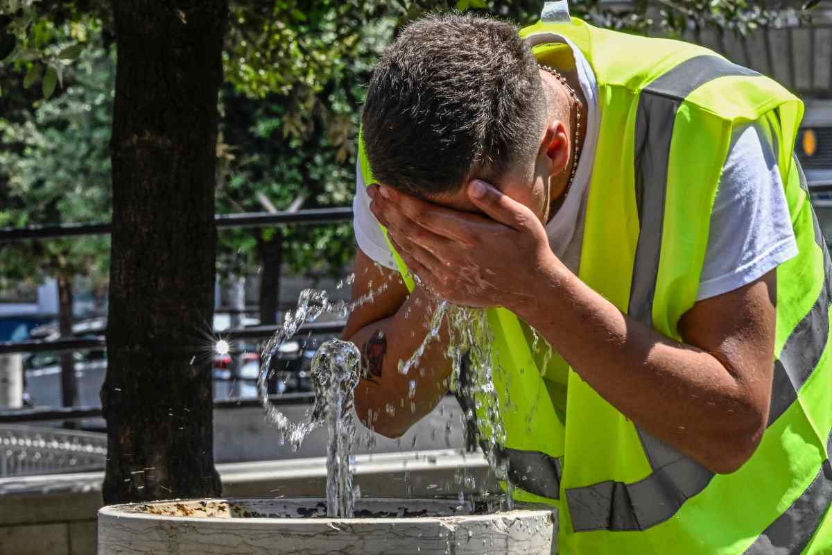 Lavoratore trova refrigerio presso una fontana, dove si bagna il viso