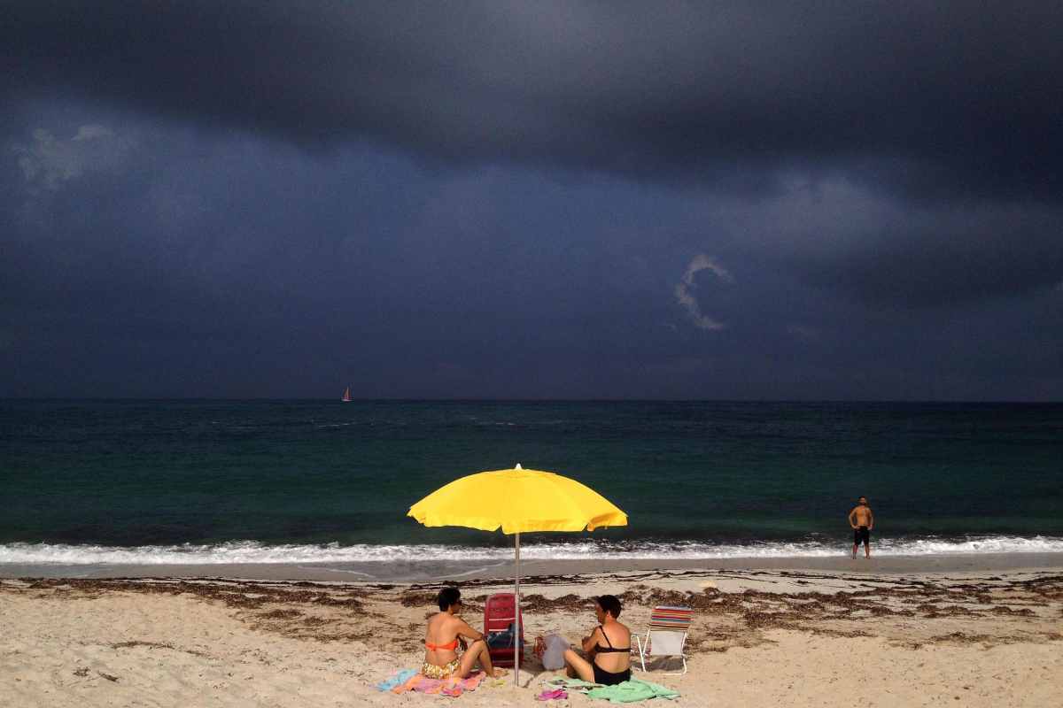 Nuvoloni neri 'minacciano' una spiaggia della Sardegna occupata da soli due bagnanti