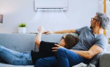 una coppia al divano che accende l'aria condizionata