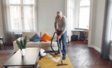 Uomo che passa aspirapolvere in soggiorno