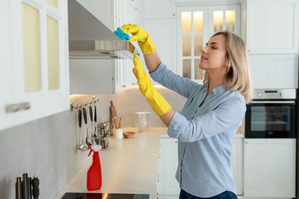 Donna che pulisce mobile della cucina