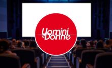 logo uomini e donne al centro e sala cinema come sfondo
