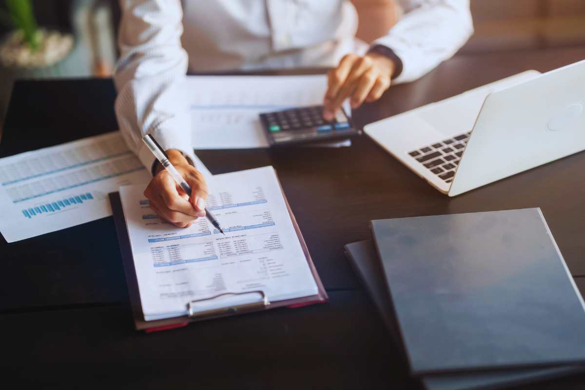 Uomo seduto alla scrivania con tante scartoffie davanti